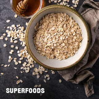 bowl of oats with honey and a cloth on a black background with the words reading superfoods.
